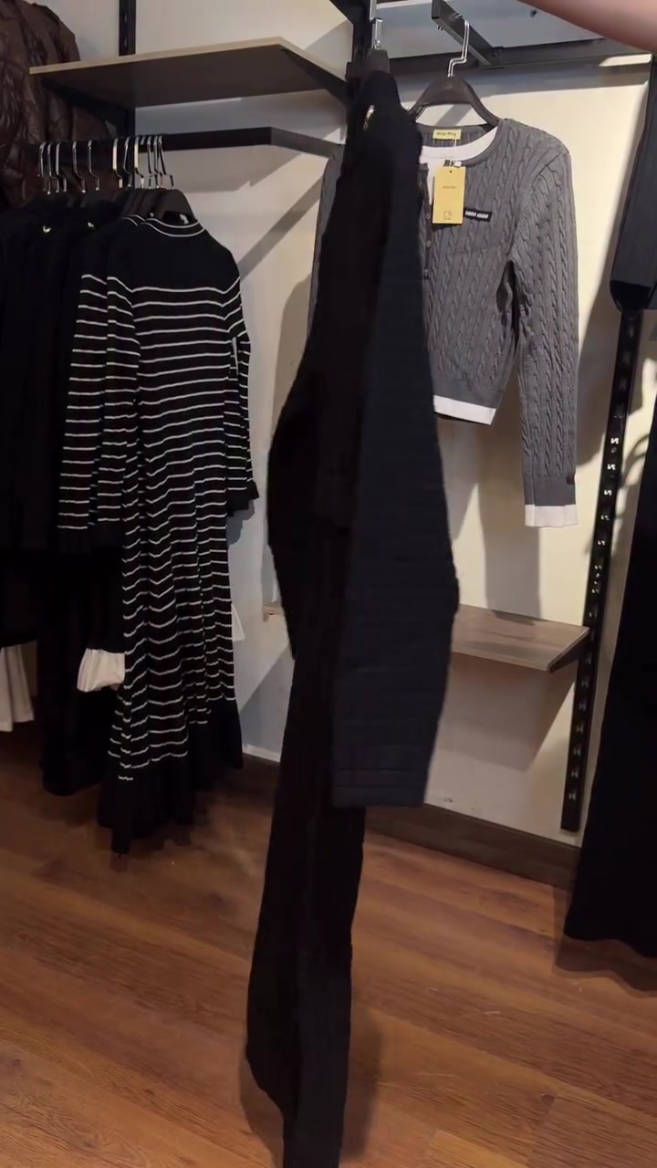 Une ceinture à boucle en B affine la taille d'un cardigan long en maille à manches longues. 