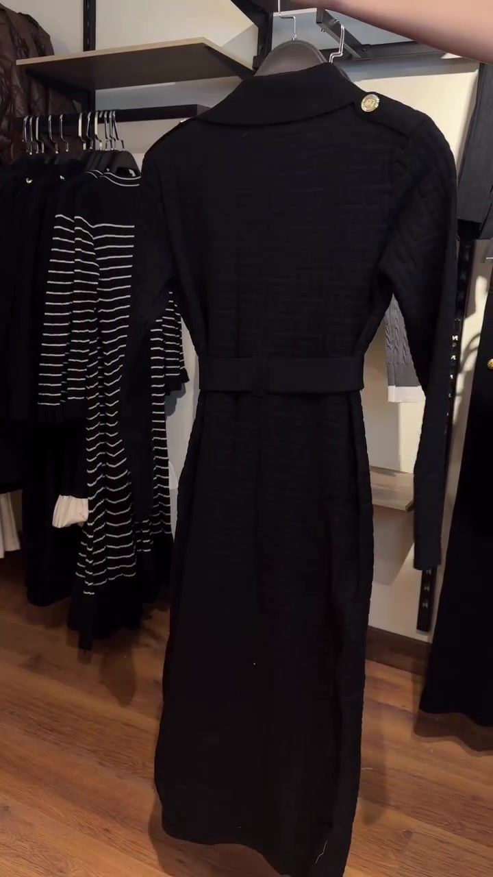 Une ceinture à boucle en B affine la taille d'un cardigan long en maille à manches longues. 