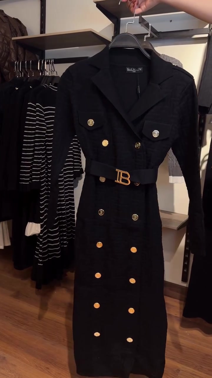 Une ceinture à boucle en B affine la taille d'un cardigan long en maille à manches longues. 